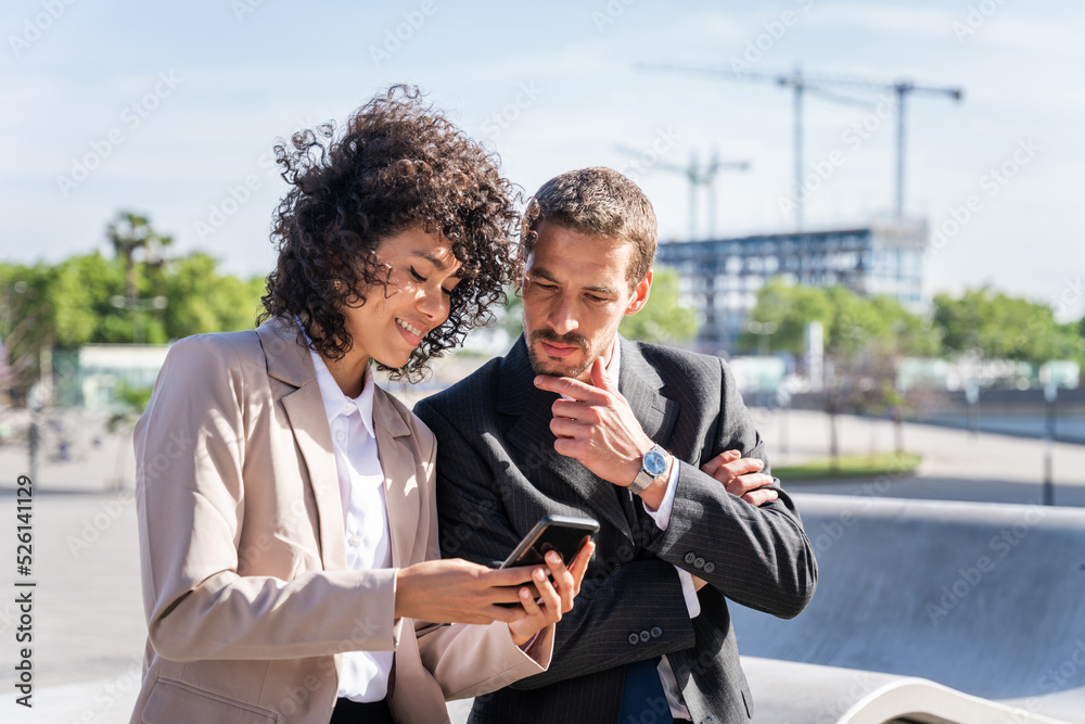 Business people meeting in a business park - Two coworkers looking at smart phone Business people meeting in a business park - Two coworkers looking at smart phone