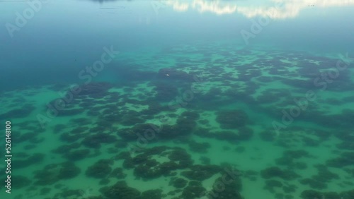 Drone moving along turquoise water in lagoon Alchichica in volcanic craters in Puebla, Mexico photo