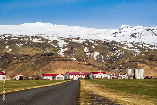 Road leading towards Thorvaldseyri farm, the famous farmstead located right in front of Eyjafjallajökull glacier and volcano with its snow-capped summit, Route 1 / Ring Road, Southern Region, Iceland