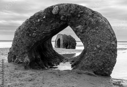 Grayscale shot of arch shaped stones on Mersehead sands, Dumfries and Galloway, Scotland photo