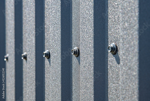 Obraz na płótnie Roofing screw in a profiled sheet close-up. The method of fastening the profiled sheet. w salonie