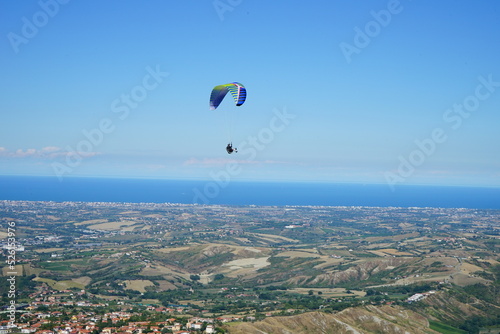 Paragliding over emilia romagna in a summer day, italy