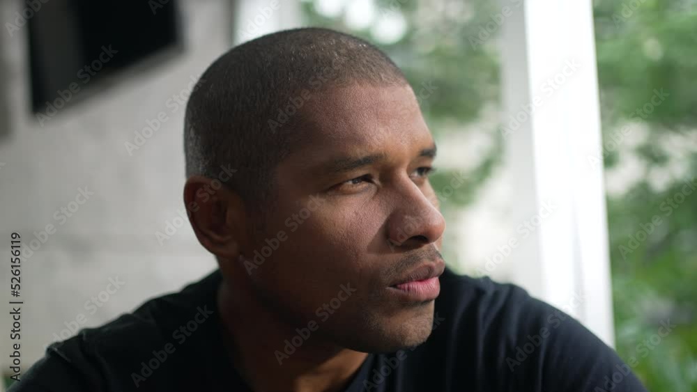 One pensive black man. Thoughtful African American person staring out window in contemplation One pensive black man. Thoughtful African American person staring out window in contemplation