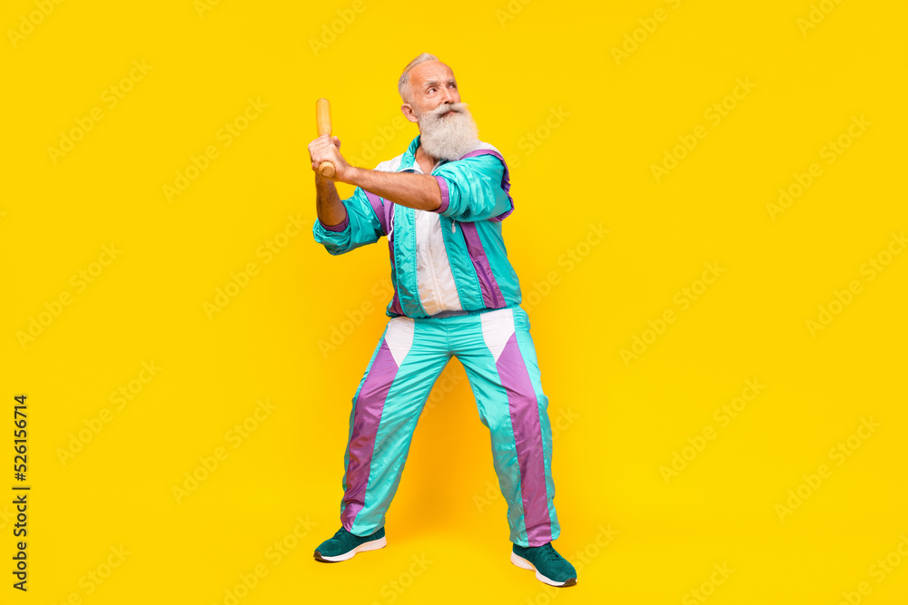 Full length portrait of serious aged person hold shoot bat empty space wear condensed milk tin color clothes isolated on yellow background Full length portrait of serious aged person hold shoot bat empty space wear condensed milk tin color clothes isolated on yellow background