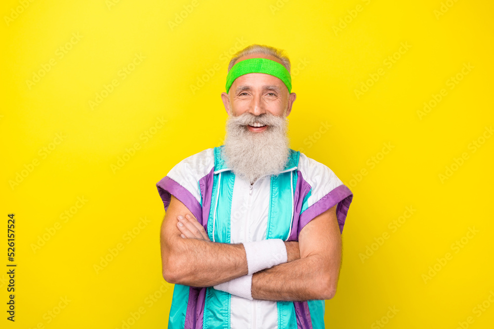 Portrait of cheerful friendly coach granddad crossed hands wear condensed milk color sport suit isolated on yellow background