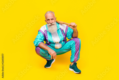 Photos Full size portrait of aged handsome person sitting arm hold baseball bat wear 90