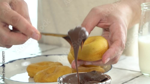 hommade donut spreading hazelnut chocolate spread on it photo