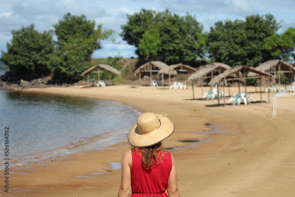 Mulher andando de costas na praia do massanori, em Altamira, Pará, margens do rio Xingu
