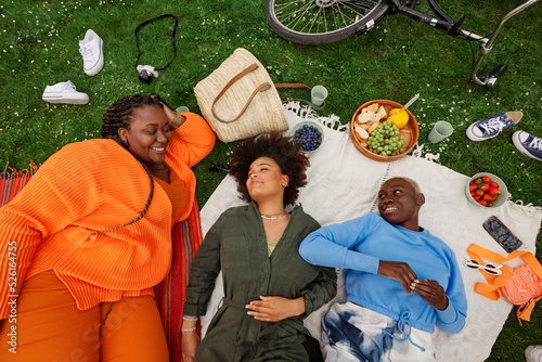 Canvas Print High angle view of female friends talking while lying on blanket in Vondelpark