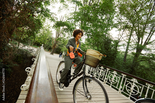 Photography Smiling young woman riding bicycle on bridge in Vondelpark