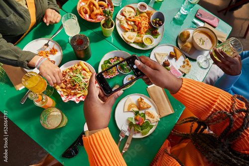 High angle view of woman taking picture of food in restaurant