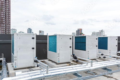 Air conditioner compressor installed on roof building. Industrial air conditioning units. Industrial air conditioning and ventilation systems on roof. Cooling towers in data center building. 