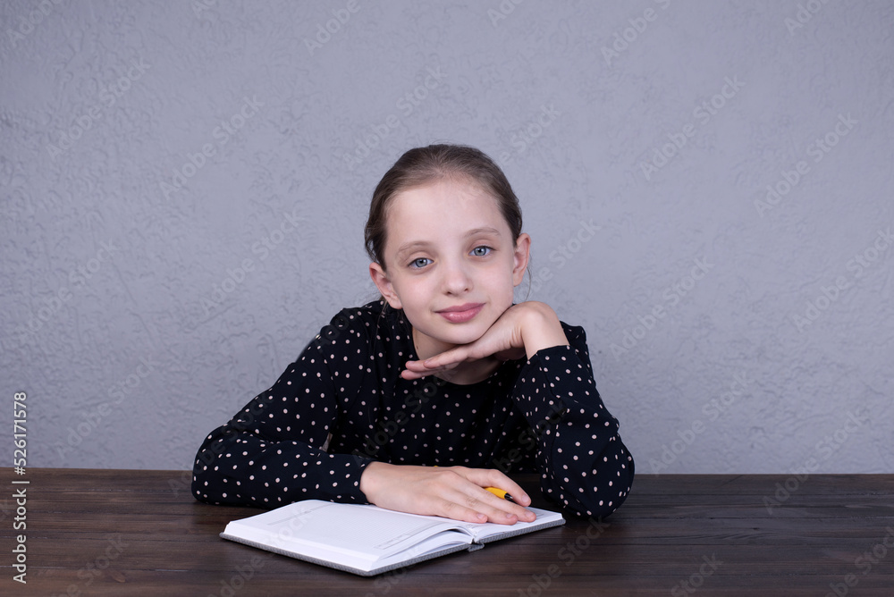 European girl sitting at the table and doing homework. Portrait of a beautiful girl. European girl sitting at the table and doing homework. Portrait of a beautiful girl.