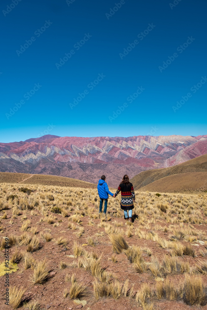 mother and son holding hands looking at the wonderful landscape in Serrania del Hornocal, Jujuy Argentina