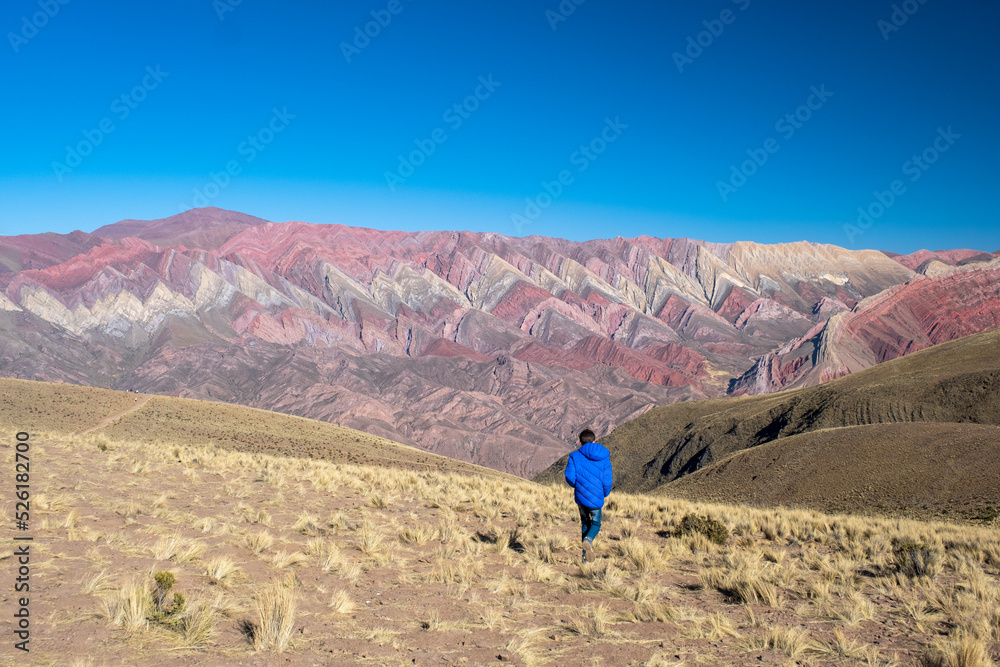 Boy walking towards the Serrania del Hornocal in Jujuy, Argentina