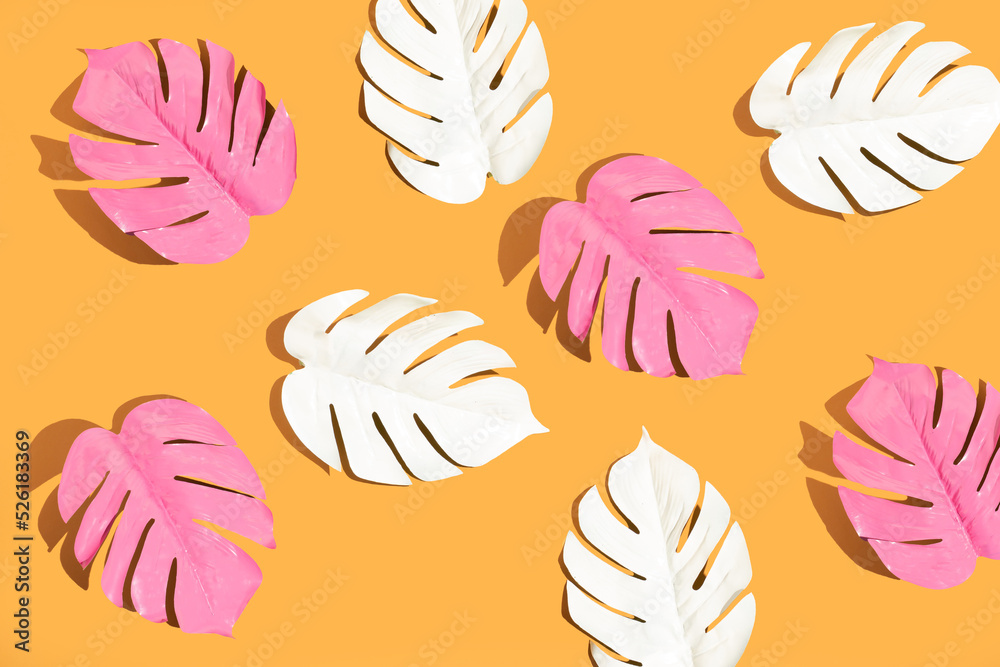 White and pink monstera leaves on yellow background. Minimal summer concept. Flat lay