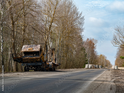 .Road traffic accident of a car with fire. Car accident. Road in the forest. Damaged transport. Asphalt pavement. Traffic Laws. Military actions. Motor vehicle. Ukraine.