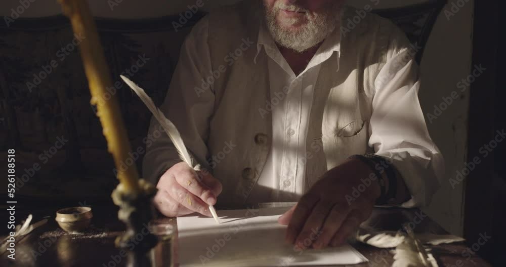 Senior man writing text with a feather on papyrus in the night time, action scene of middle ages time, crane shot, tilt up. Senior man writing text with a feather on papyrus in the night time, action scene of middle ages time, crane shot, tilt up.