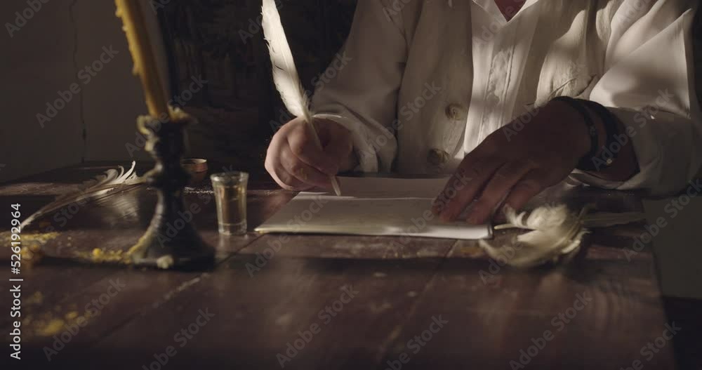 Hands of a male person while writing document tex on papyrus in the night time, action scene, crane shot, close-up.