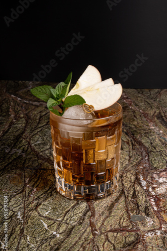 Fotografija Cóctel sobre fondo negro en un bar con garnitura de manzana mezcal tequila bar v