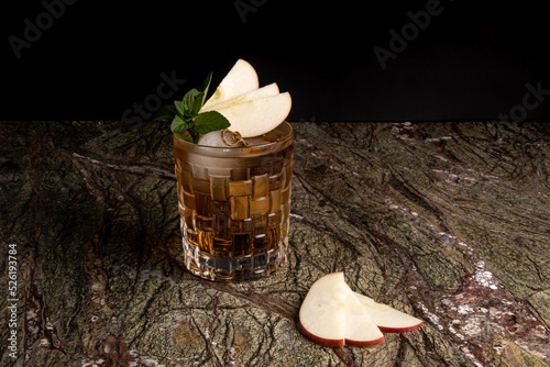 Cóctel sobre fondo negro en un bar con garnitura de manzana mezcal tequila bar vodka wiskey tonic  photo