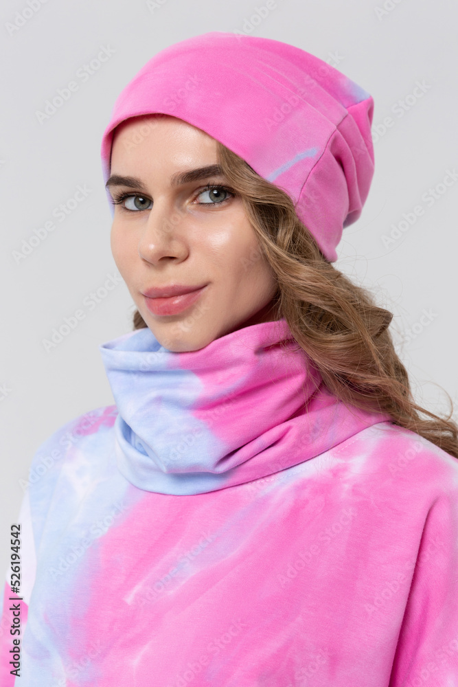 Beautiful woman with a Snood Scarf around her neck in the winter hat. Girl in spring clothes, warm sweatshirt Beautiful woman with a Snood Scarf around her neck in the winter hat. Girl in spring clothes, warm sweatshirt