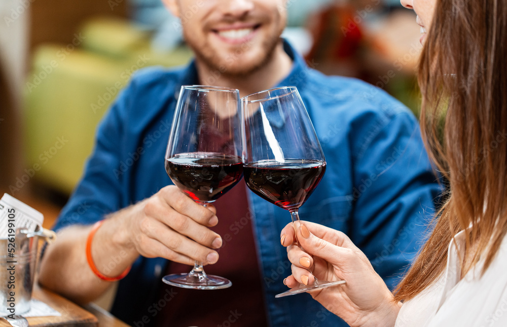 leisure, drinks and people concept - close up of happy couple drinking red wine at restaurant