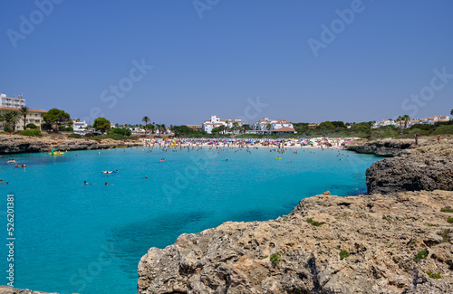 Menorca, Spain: Cala en Bosch beach minorca . Cami de cavalls. Beautiful minorca beach with small hotel in the background. white sand and turquoise water