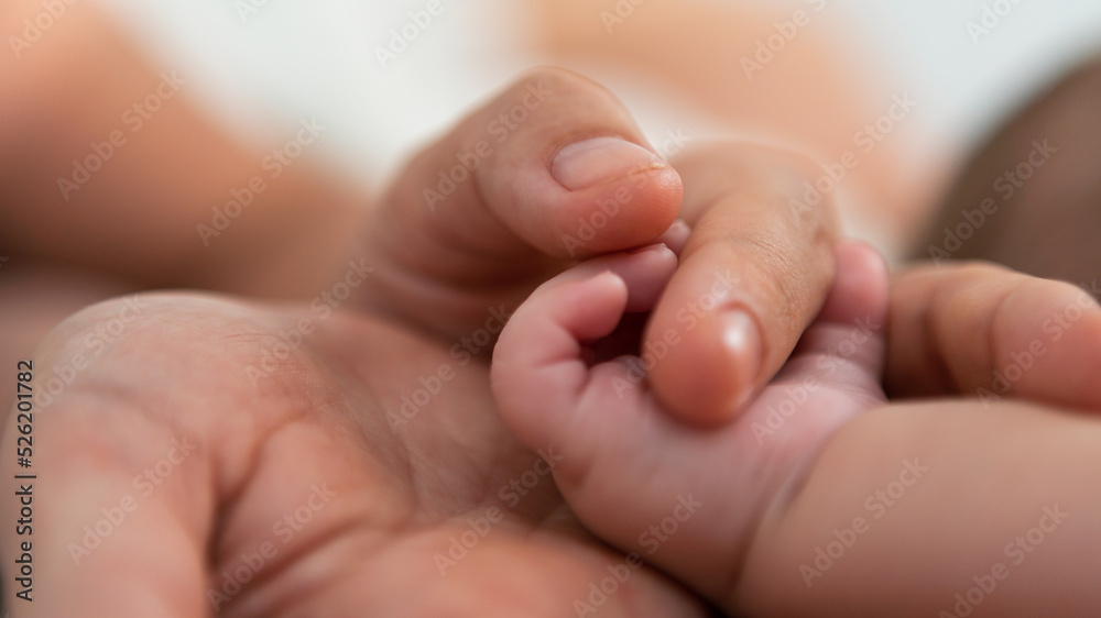 Close up mother holding hands newborn boy in a room with a lot of sunlight. Baby Close up mother holding hands newborn boy in a room with a lot of sunlight. Baby