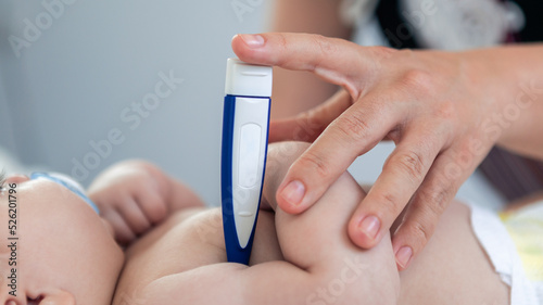 Doctor checking the temperature fever to small newborn with thermometer.