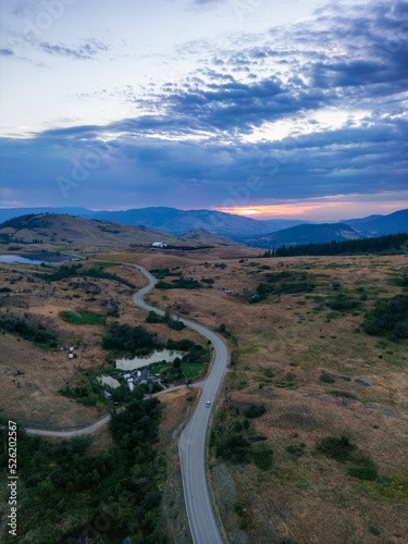 Aerial View of a Scenic Road in the Desert during colorful cloudy sunrise. Near Vernon, Okanagan, British Columbia, Canada.