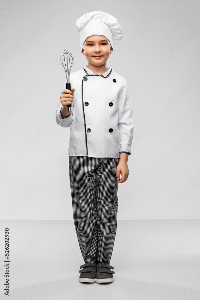 cooking, culinary and profession concept - happy smiling little boy in chef's toque and jacket with whisk over grey background cooking, culinary and profession concept - happy smiling little boy in chef's toque and jacket with whisk over grey background