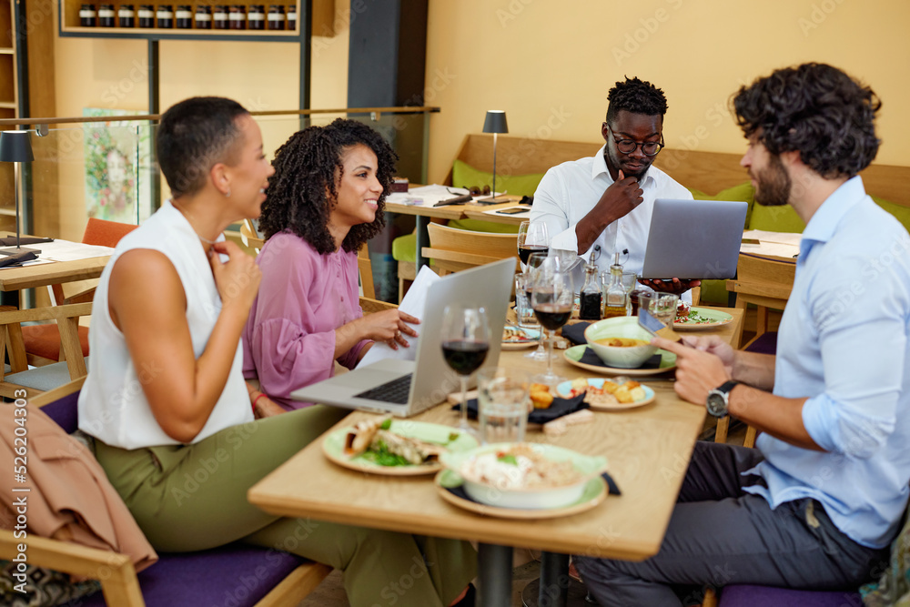 The colleagues at the dinner table in the restaurant sit and have a business meeting and brainstorm. The colleagues at the dinner table in the restaurant sit and have a business meeting and brainstorm.