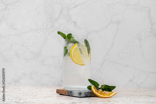 Cóctel Mojito fresco con limón amarillo en vaso higball en fondo de mármol, menta,  hielo en vidrio sobre fondo gris. Bebidas, bebidas y cócteles alcohólicos fríos de verano photo