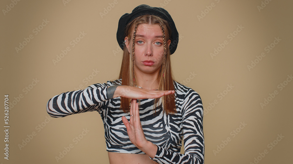 Time out, need a break. Tired serious upset pretty young woman in crop top showing pause relax gesture, limit or stop sign. Adult stylish female girl isolated alone on beige studio background indoors Time out, need a break. Tired serious upset pretty young woman in crop top showing pause relax gesture, limit or stop sign. Adult stylish female girl isolated alone on beige studio background indoors