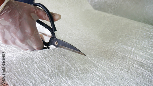 Fiberglass material cutting by scissors. close up view
