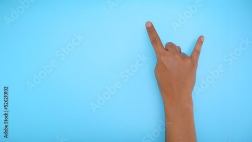 Male hand showing hand sign isolated on blue background 