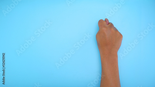 Male hand showing hand sign isolated on blue background 