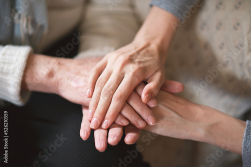 Elderly woman holding hands with daughter
