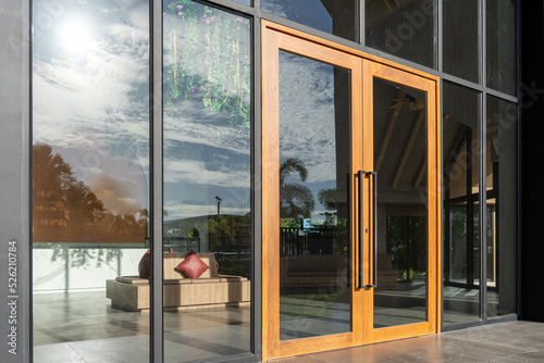 Glass door entrance to a large apartment hotel, the material is wood and steel, beautifully decorated.