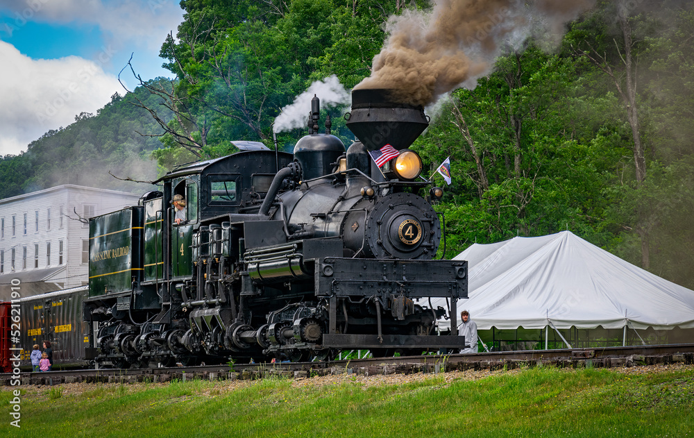 Obraz premium Cass, West Virginia, June 18, 2022 - A View of an Antique Shay Steam Engine Warming Up, Blowing Smoke and Steam on a Sunny Day
