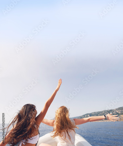 Beautiful girl friends arms raised travel on speed boat to paradise island for relaxing nature tourist destination vacation discover explore