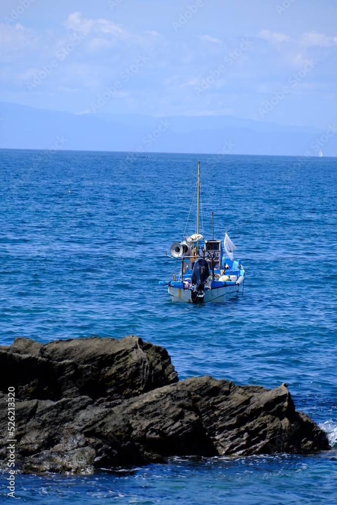 青空のもと沖合で漁に励む漁船