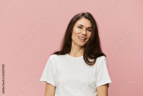 horizontal portrait of a cute attractive woman on a pink background in a clean white tank top smiling pleasantly at the camera