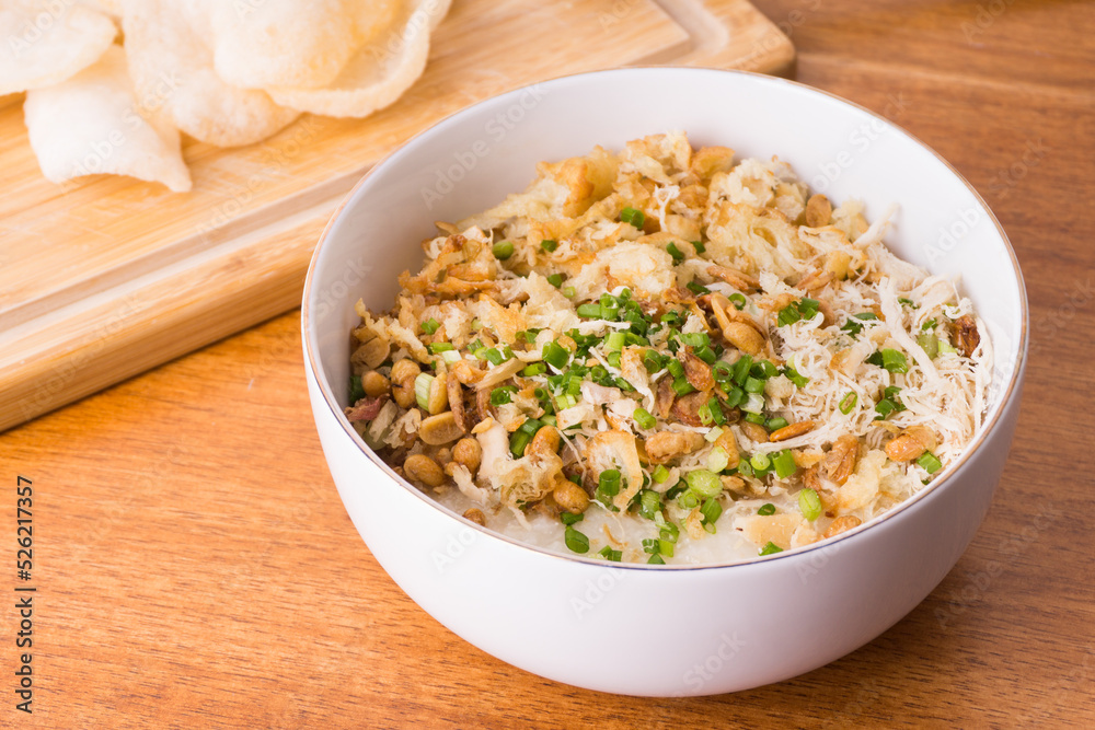 Close up view of Chicken congee or chicken porridge. Equipped with shredded chicken, cakwe or youtiao, garlic crackers, peanuts and spring onions Close up view of Chicken congee or chicken porridge. Equipped with shredded chicken, cakwe or youtiao, garlic crackers, peanuts and spring onions