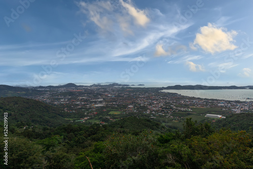 Chalong Bay Beach in Phuket Thailand, turquoise blue waters, lush green mountains colourful skies. Phuket is a tropical island many palms