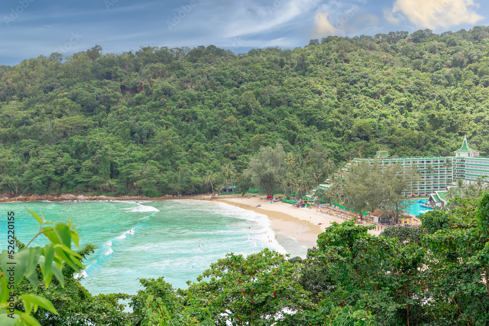 Freedom Beach in Phuket Thailand, turquoise blue waters, lush green mountains colourful skies. Phuket is a tropical island many palms