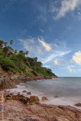 Promthep Cape Beach in Phuket Thailand, turquoise blue waters, lush green mountains colourful skies. Phuket is a tropical island many palms