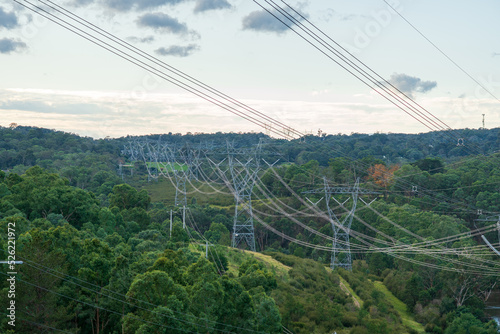 High voltage overhead power lines, electric power transmission, electricity transmitting against sky background.