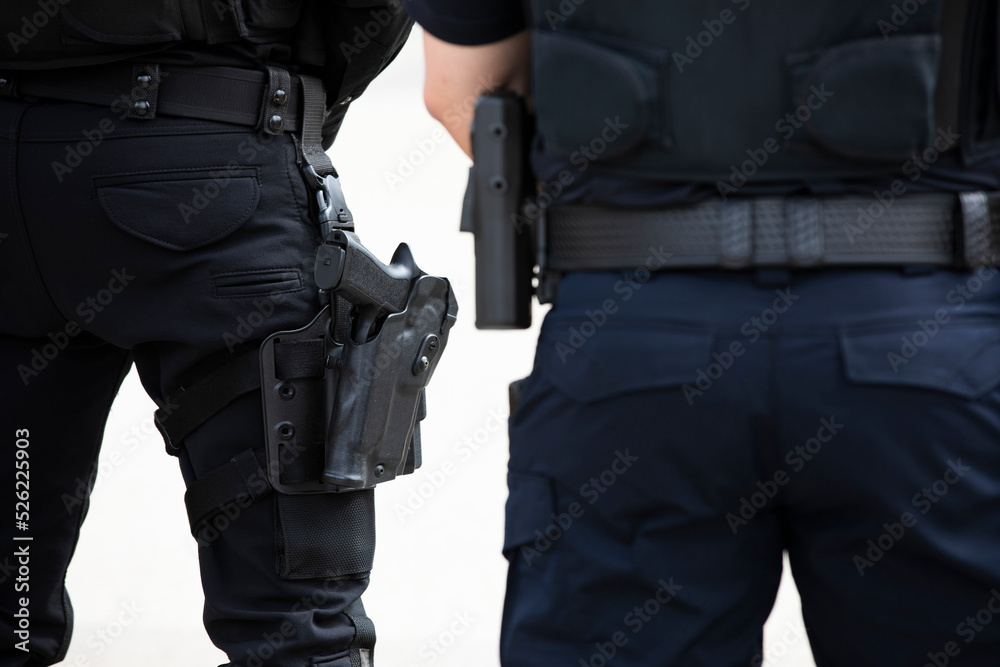 Daytime view of a white police officer's utility belt and gun holster. Daytime view of a white police officer's utility belt and gun holster.